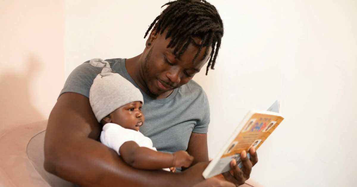 Man reading to newborn baby