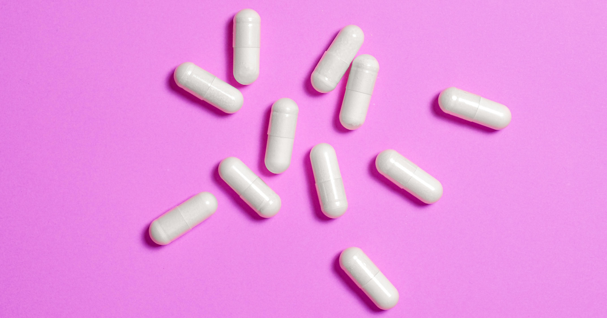 HRT pills on pink background